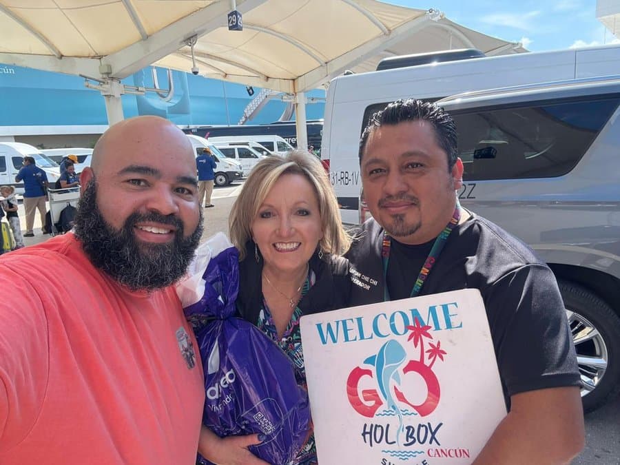 Go Holbox Shuttle team welcoming guests at Cancún Airport with a welcome sign